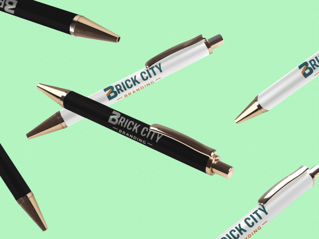 A collection of premium black and white pens with rose gold accents and the Brick City Branding logo, floating against a mint green background.