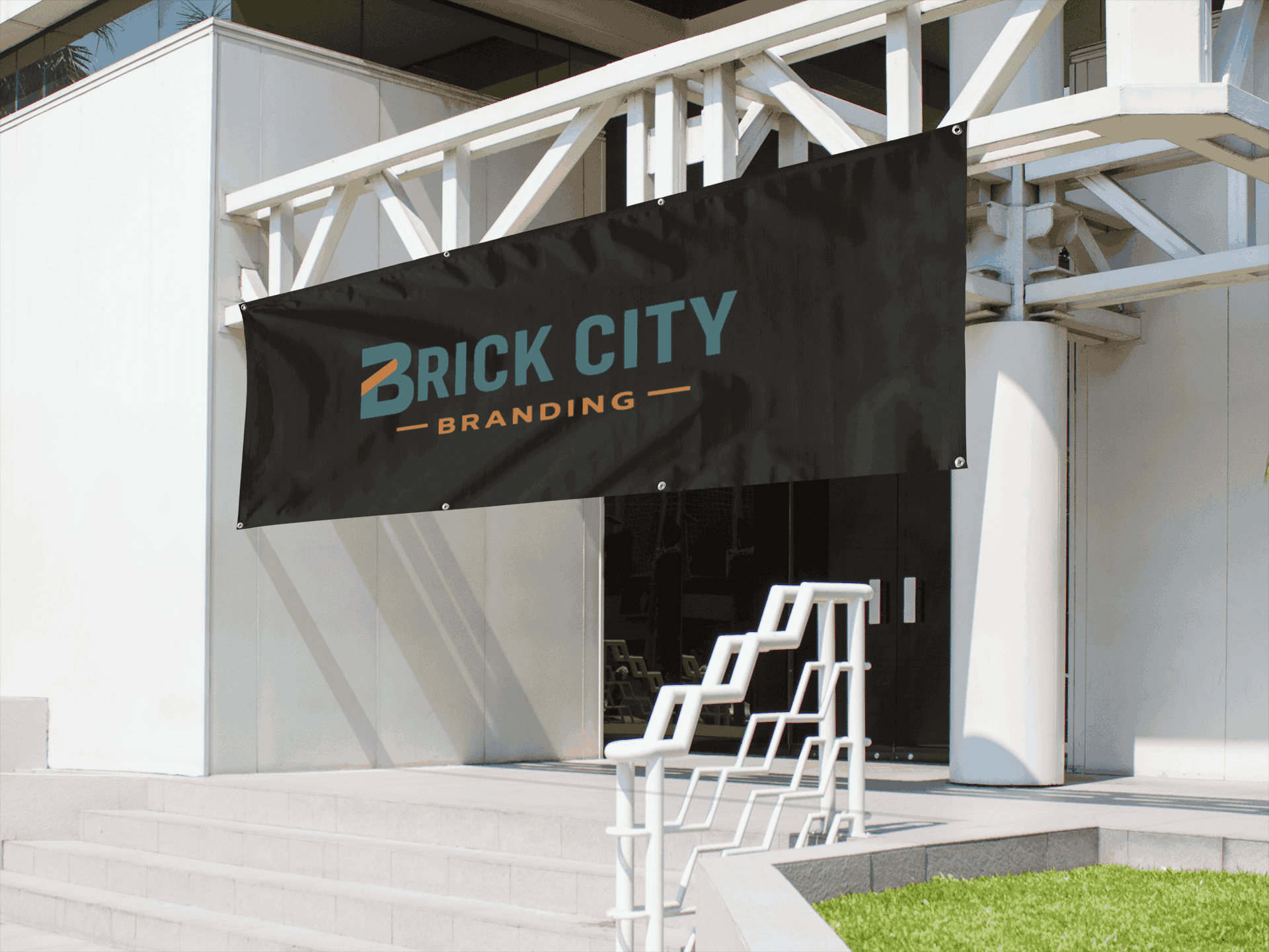 Large black custom vinyl business banner for Brick City Branding hanging on a white modern building exterior.