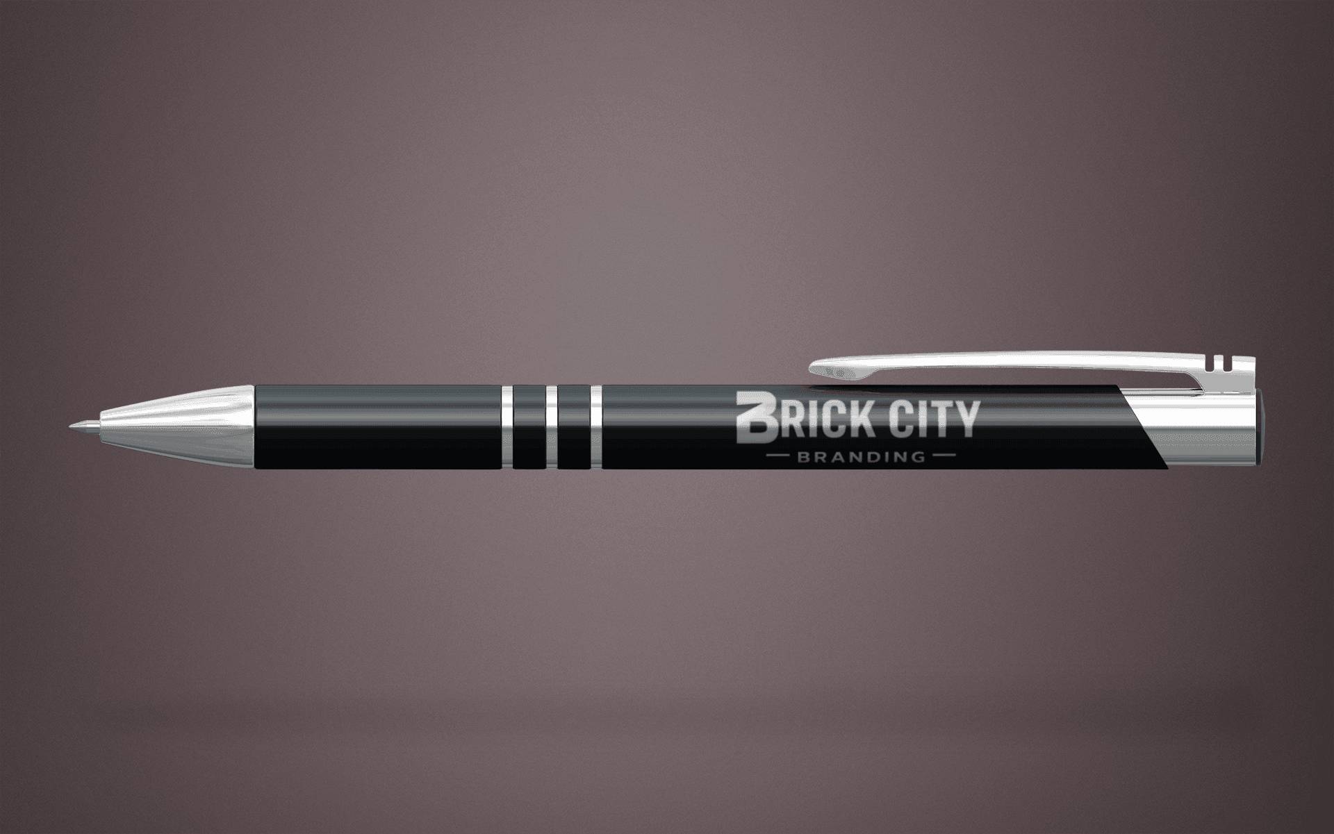 A luxury black and chrome metal executive pen with the Brick City Branding logo laser-engraved on the barrel, featuring silver accents.